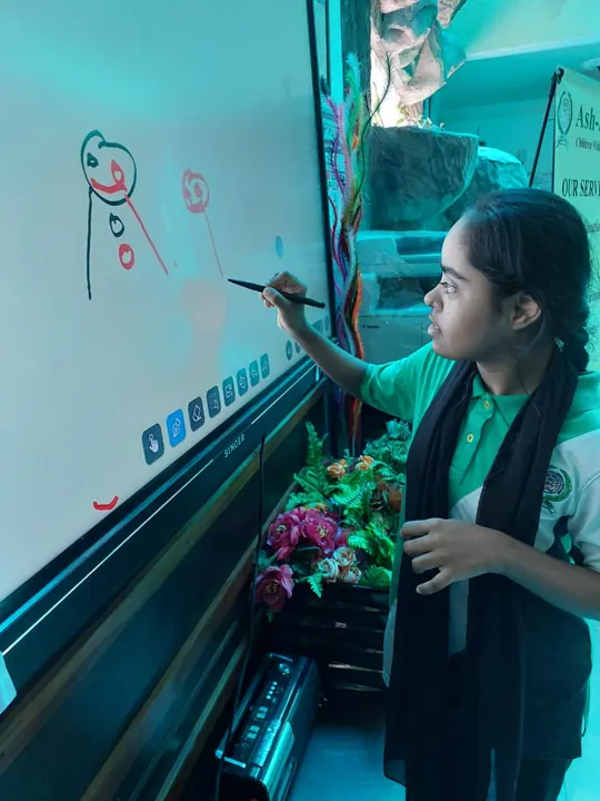 A student drawing faces on the smart board